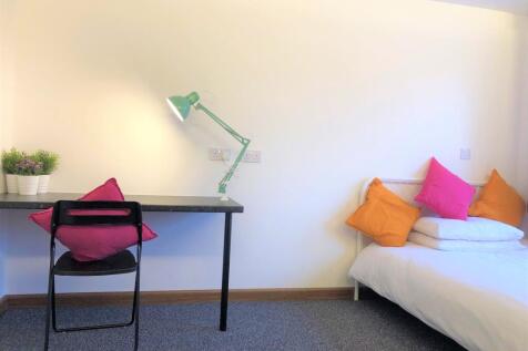 A bright and tidy single bedroom featuring a co...