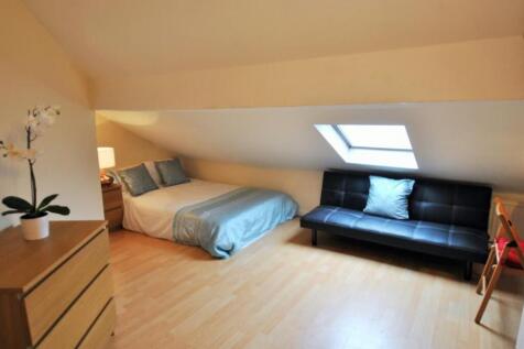 Spacious attic bedroom with double bed and sofa...