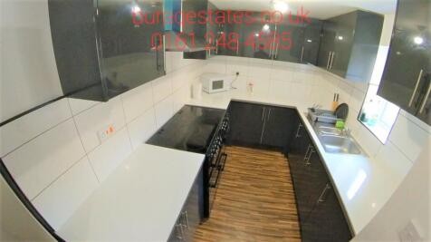 Modern galley kitchen with sleek white worktops...