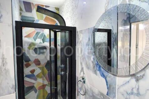 Stylish bathroom with a patterned walk-in showe...