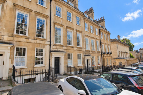 Sunlit Georgian Townhouses and Parked Cars.png