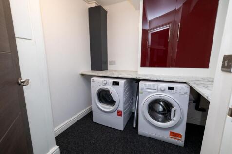 A compact kitchen equipped with a washing machi...