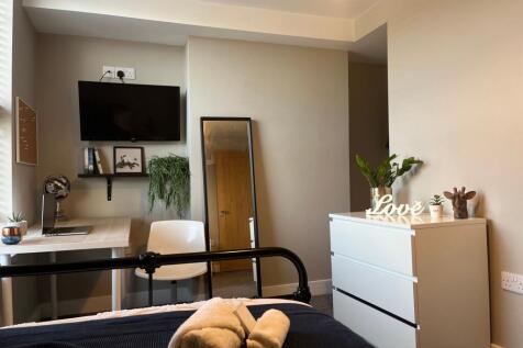 Bright, neatly styled bedroom with a desk works...