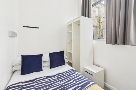 Bright, simply furnished bedroom with a neatly ...