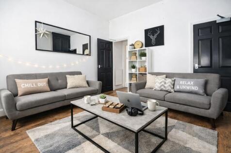 Stylish lounge with modern sofas and fairy ligh...