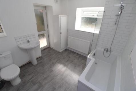 Spacious modern bathroom with sleek white tilin...