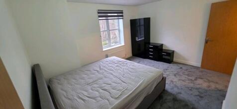 Bright, modern master bedroom with a double bed...