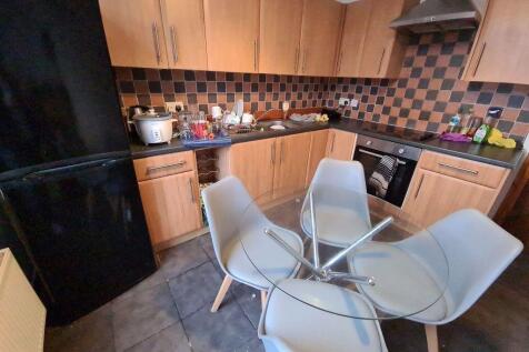 Modern kitchen with wooden cabinetry and a tile...