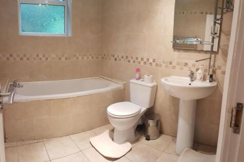 Bright, well-kept bathroom with a corner bathtu...