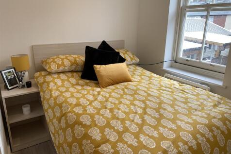Bright double bedroom with patterned bedding an...