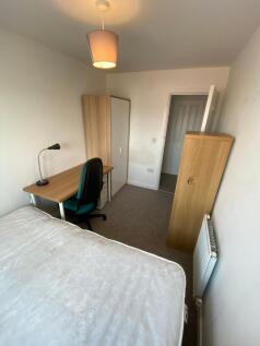 A cozy student bedroom featuring a comfortable ...