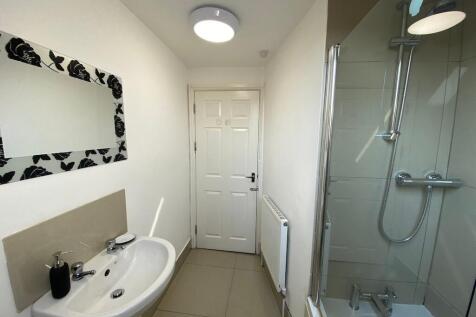 Bright, modern bathroom with a glass-enclosed s...