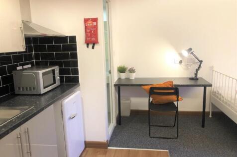 A neat and functional student room featuring a ...