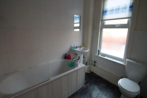 A bright and clean bathroom featuring a toilet,...
