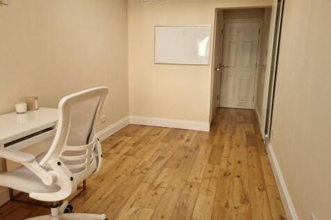 Bright study area with desk and wooden floor...