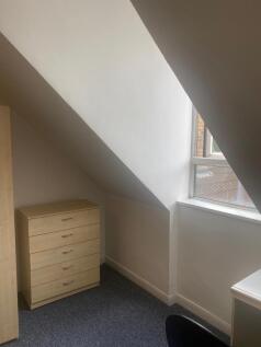 Bright attic bedroom corner with a sloped ceili...