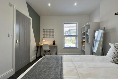 A bright and spacious double bedroom with a coz...