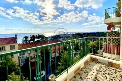 A balcony with a decorative tile floor overlooks a