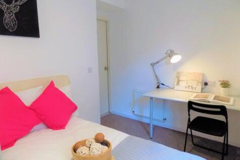 A neat and cozy bedroom featuring a single bed ...