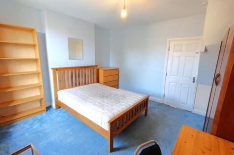 Bright, well-presented bedroom with a wooden do...