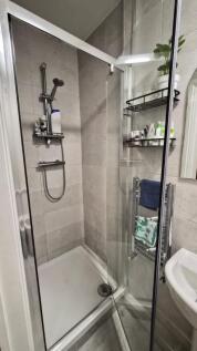Modern tiled bathroom with a glass shower enclo...