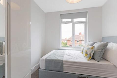 A bright and modern double bedroom featuring st...