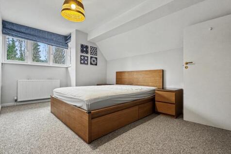 Bright, simply styled double bedroom with a woo...