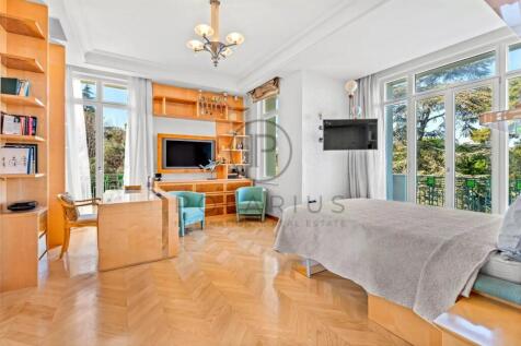 Bright and spacious bedroom with wooden floors, a 