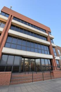 Modern mid-rise building with large tinted wind...