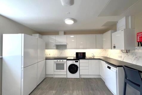 Bright, modern fitted kitchen with white gloss ...