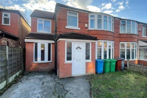 Red-brick terraced house with bay windows, a pa...