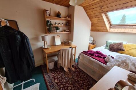Bright attic master bedroom featuring a cozy do...