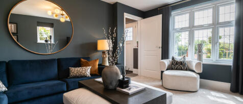 Redrow lounge with bright window, dark furniture and stylish furnishings at Oakleigh Fields