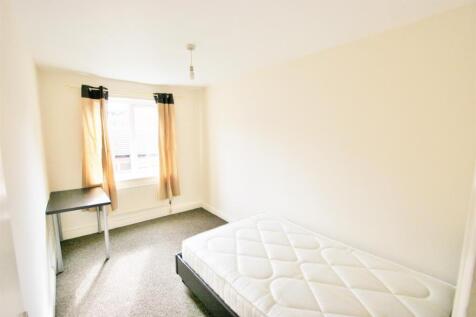 A bright and simple single bedroom with a windo...