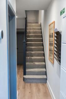 Bright, modern tiled-carpet staircase in a well...