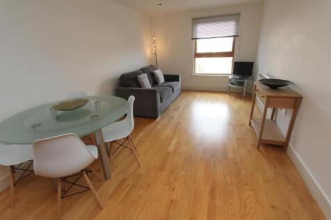 Bright living area with stylish wood flooring...