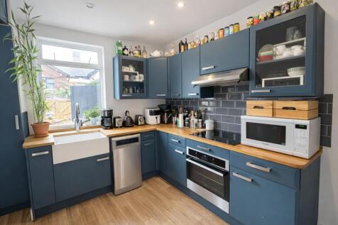 Contemporary blue kitchen with wooden counterto...