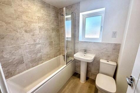 Bright, modern bathroom with a bathtub and glas...