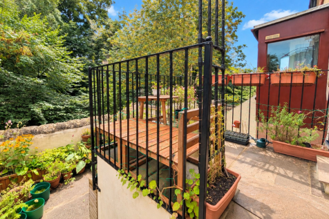 A Raised Garden Terrace With A Woodland Backdrop