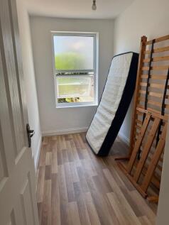 Bright room with wood-effect flooring and windo...