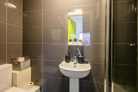 Modern tiled bathroom with a pedestal sink, wal...