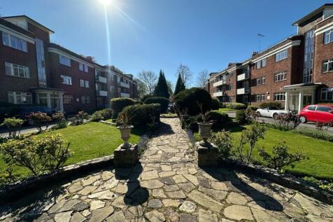 Lush manicured garden with sunlit stone path...