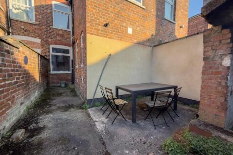 Private paved rear yard with outdoor seating...