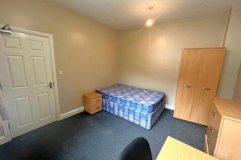 Bright, simply furnished bedroom with a single ...