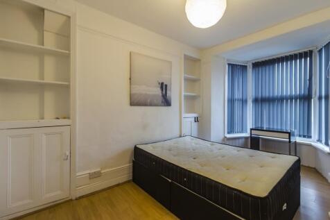 Bright bedroom with built-in storage and bay wi...