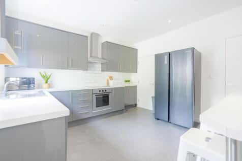 Modern and bright kitchen featuring sleek grey ...