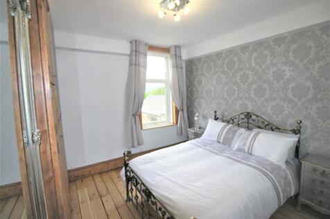 Bright bedroom with stylish feature wallpaper...