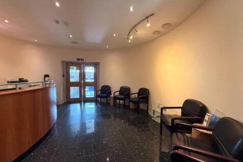 Welcoming reception area with a curved wooden d...