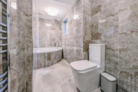 Modern bathroom with marble-effect tiled walls ...