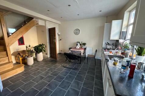 Bright open-plan kitchen with modern tiled floo...